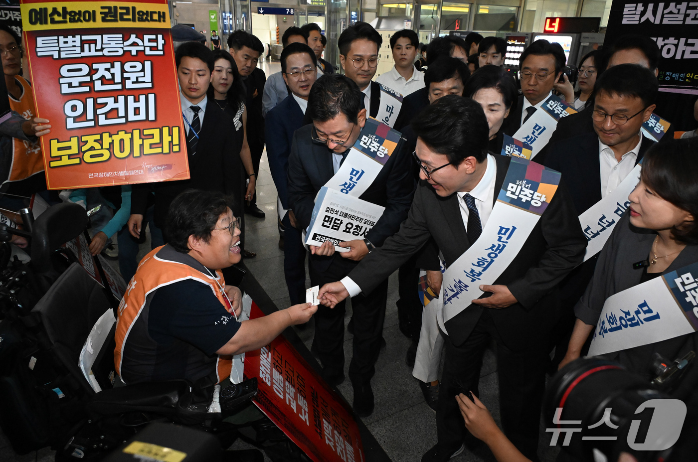 (서울=뉴스1) 유승관 기자 = 김민석 더불어민주당 대표가 23일 용산역 대합실에서 추석을 앞두고  전국장애인철폐연대 회원과 인사를 하고 있다. (공동취재) 2026.9.23/뉴스 …