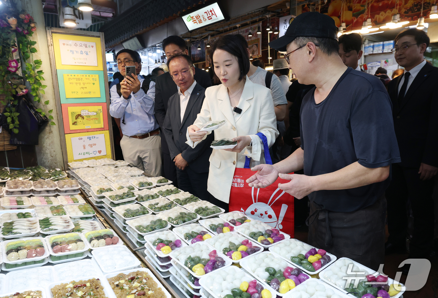 (수원=뉴스1) 김영운 기자 = 이소영 중소벤처기업부 장관이 23일 경기 수원시 팔달구 못골시장을 방문해 떡을 구매하고 있다. 2026.9.23/뉴스1