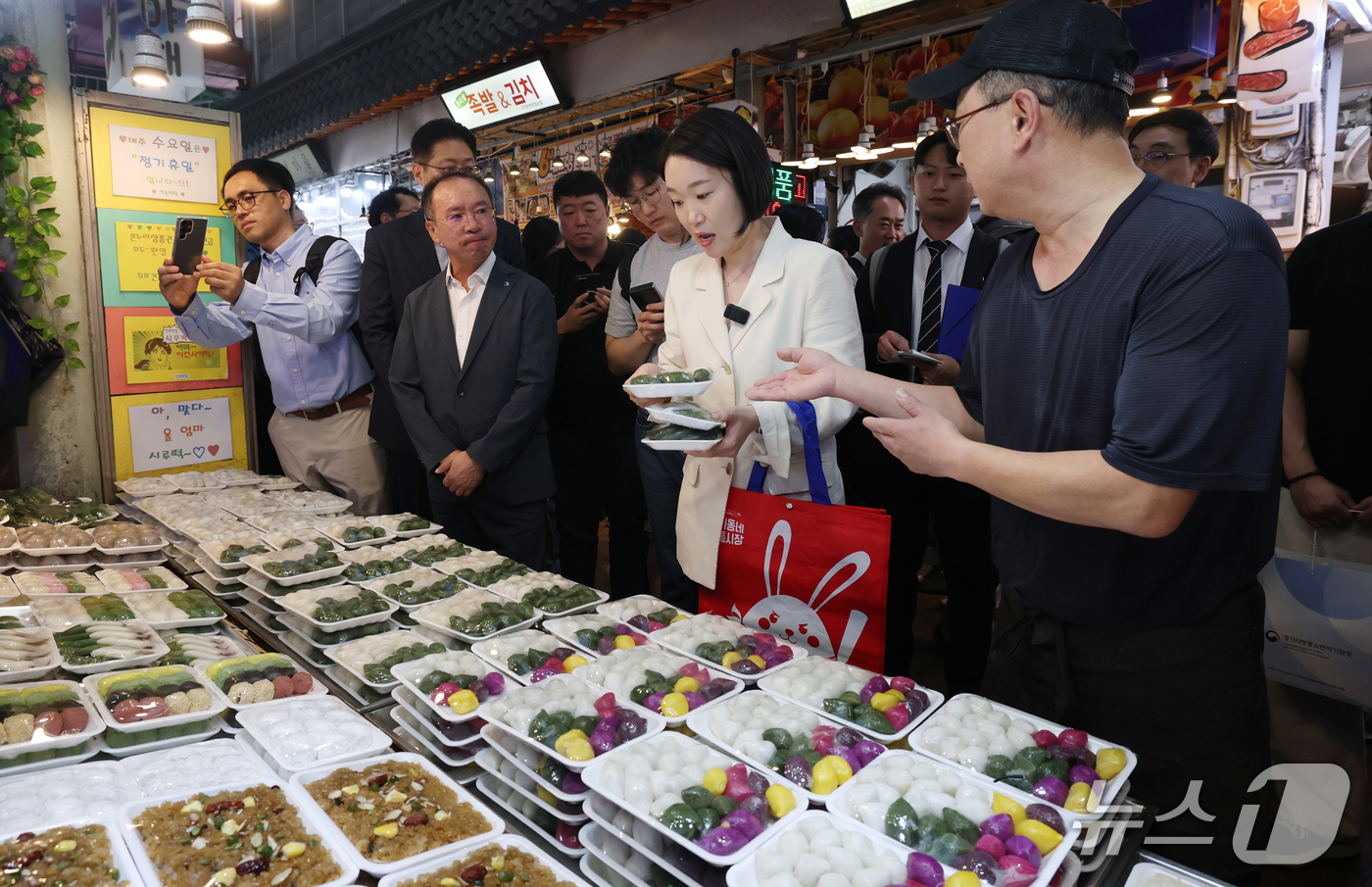 (수원=뉴스1) 김영운 기자 = 이소영 중소벤처기업부 장관이 23일 경기 수원시 팔달구 못골시장을 방문해 떡을 구매하고 있다. 2026.9.23/뉴스1