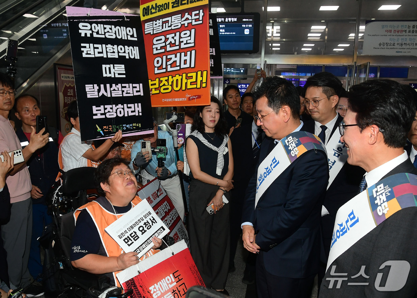 (서울=뉴스1) 유승관 기자 = 추석 연휴를 하루 앞둔 23일 오전 서울 용산역에서 김민석 대표를 비롯한 더불어민주당 의원들이 전국장애인차별철폐연대 관계자와 대화하고 있다. (공동 …
