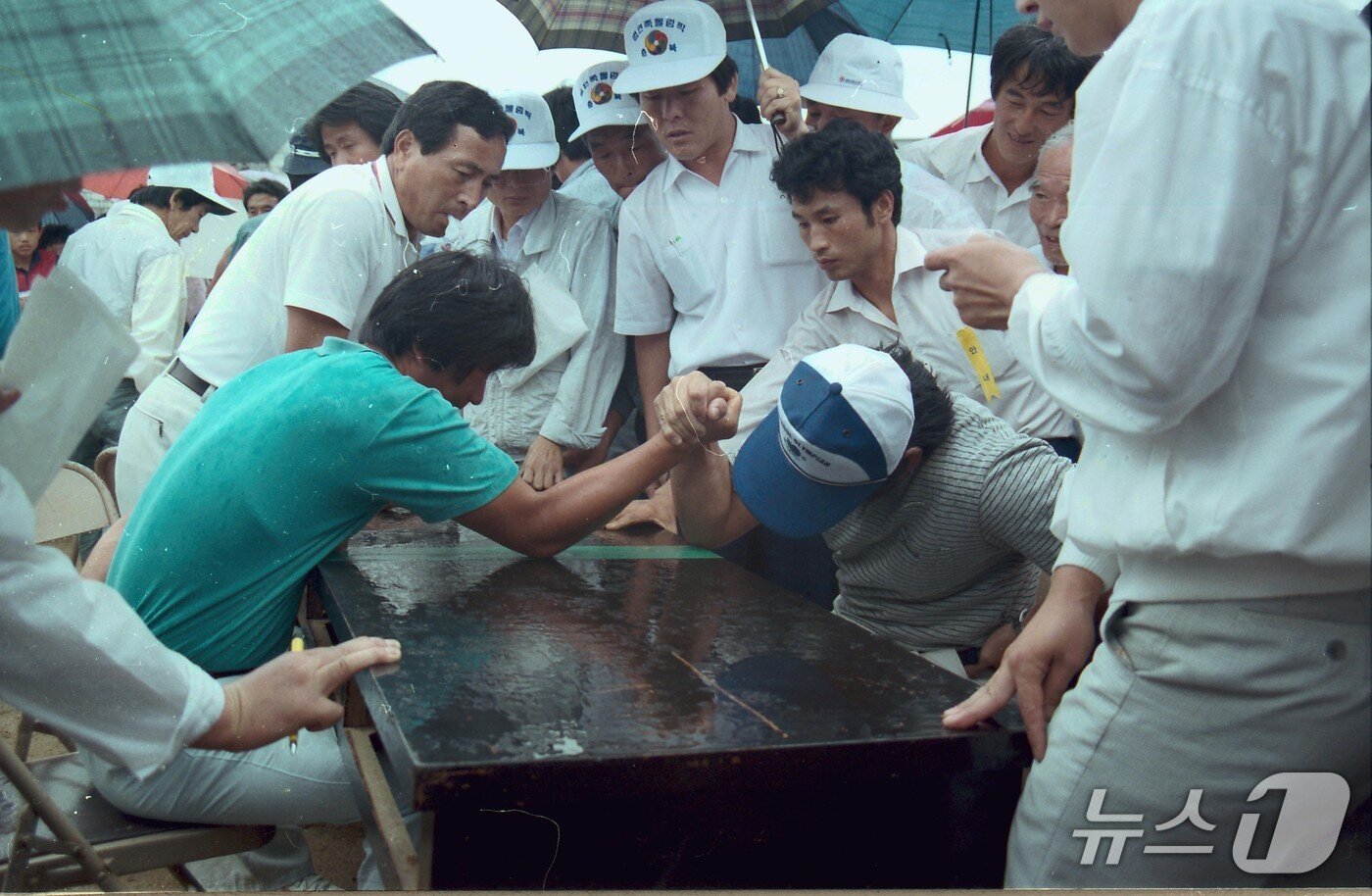 본문 이미지 - 1980년대 제천의림문화축제에서 사내들이 팔씨름으로 힘겨루기를 하고 있다. (제천시 제공. 재판매 및 DB금지) 2026.9.27/뉴스1  
