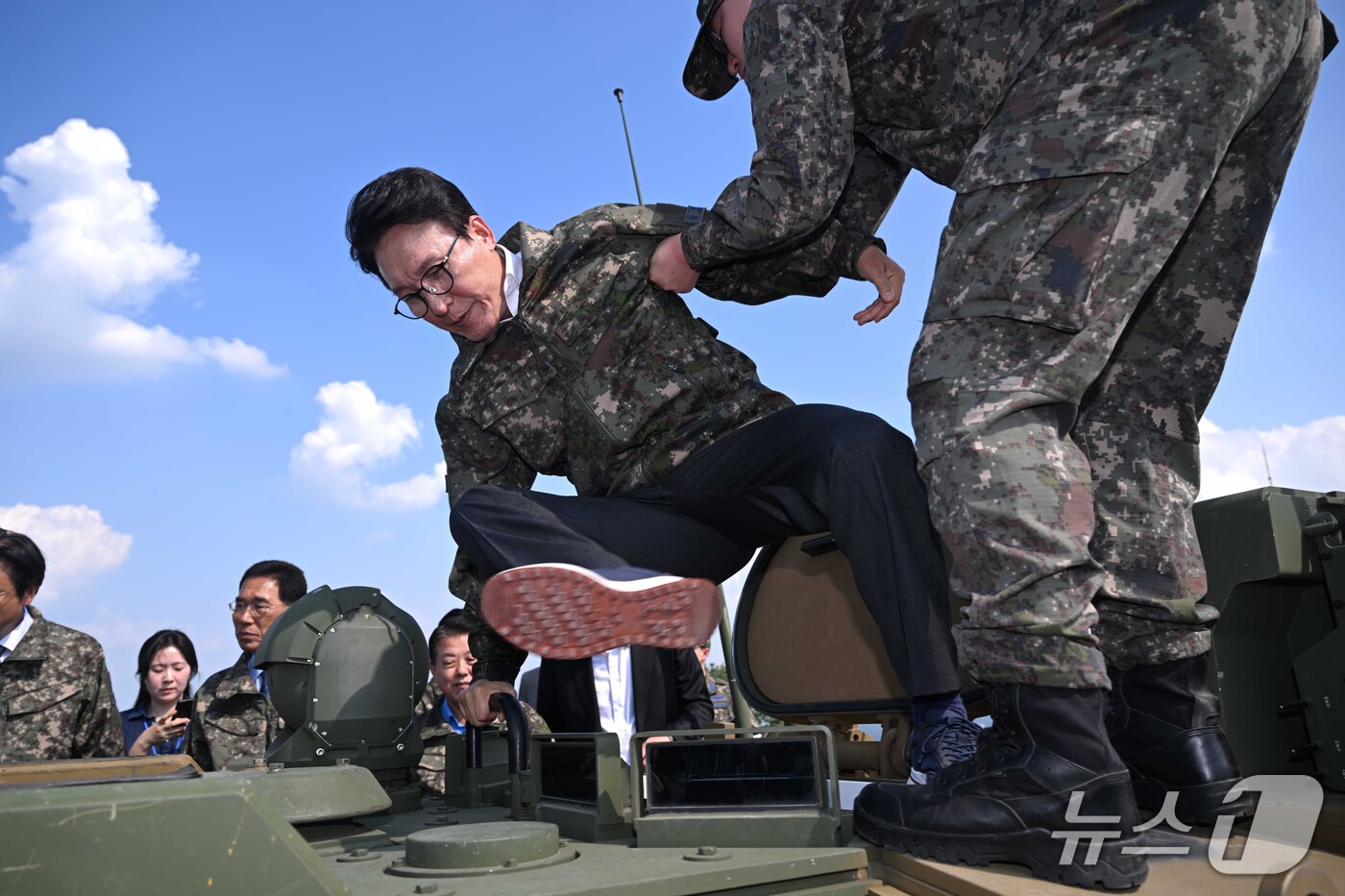 (김포=뉴스1) 국회사진기자단 = 김민석 더불어민주당 대표가 23일 오후 경기 김포시 공군3미사일방어여단 예하부대를 방문해 30mm차륜형대공포 '천호'를 하차하기 위해 장병의 도움 …