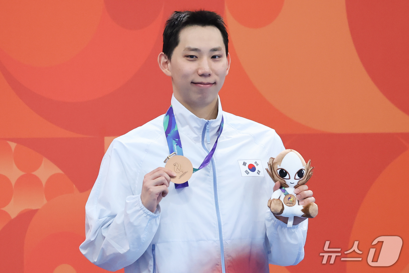 (도쿄=뉴스1) 김민지 기자 = 24일 도쿄 아쿠아틱스 센터에서 열린 2026 아이치·나고야 아시안게임 수영 남자 200m 평영 시상식에서 동메달을 확보한 조성재가 메달을 들어보이 …