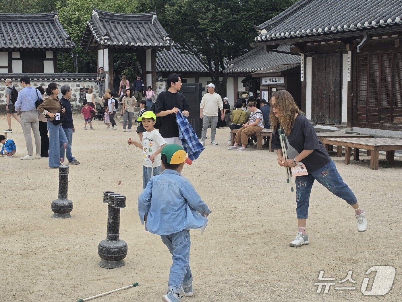 본문 이미지 - 25일 오전 서울 중구 남산골한옥마을에서 외국인 관광객들과 아이들이 투호놀이 체험을 하고 있다. 2026.09.25. ⓒ 뉴스1 권준언 기자