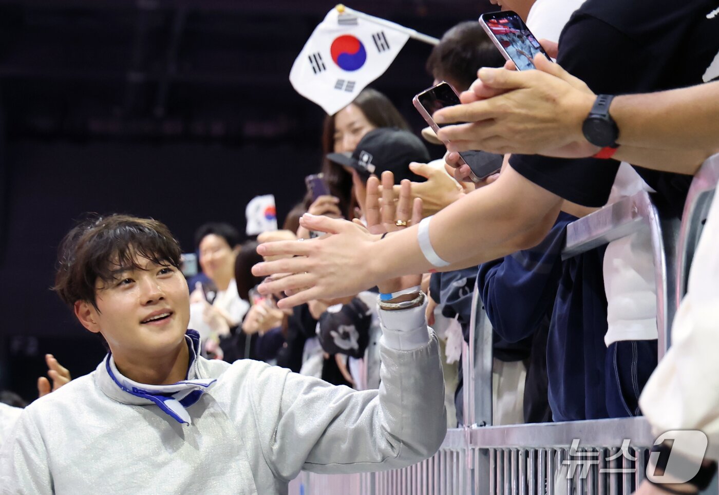 본문 이미지 - 26일 일본 아이치현 도코나메 아이치 스카이 엑스포에서 열린 2026 아이치·나고야 아시안게임 펜싱 남자 사브르 단체전 결승에서 역전 드라마를 쓰며 아시안게임 4연패를 달성한 오상욱이 응원을 나온 팬들과 인사하고 있다. 2026.9.26 ⓒ 뉴스1 김민지 기자