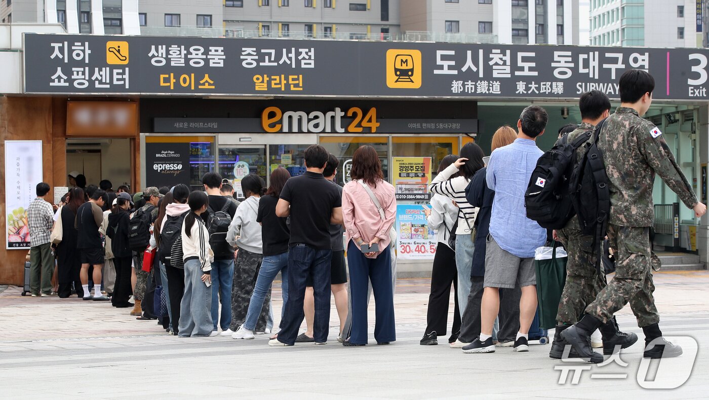 본문 이미지 - 추석 연휴 마지막 날인 27일 오전 대구 동구 동대구역 광장에서 귀경열차 탑승을 앞둔 시민들이 최근 맛집으로 소문난 떡집에서 과일찹쌀떡을 사기 위해 줄지어 차례를 기다리고 있다. ⓒ 뉴스1