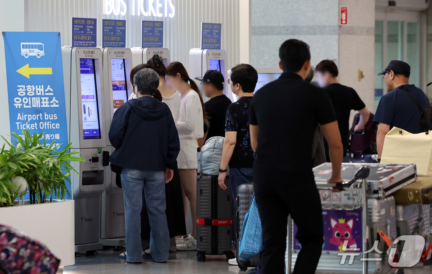 (인천공항=뉴스1) 김진환 기자 = 추석 연휴 마지막 날인 27일 인천국제공항 제1터미널 입국장 밖 버스정류장에서 해외 여행에서 돌아온 여행객들이 무인매표소에서 티켓을 구매하고 있 …