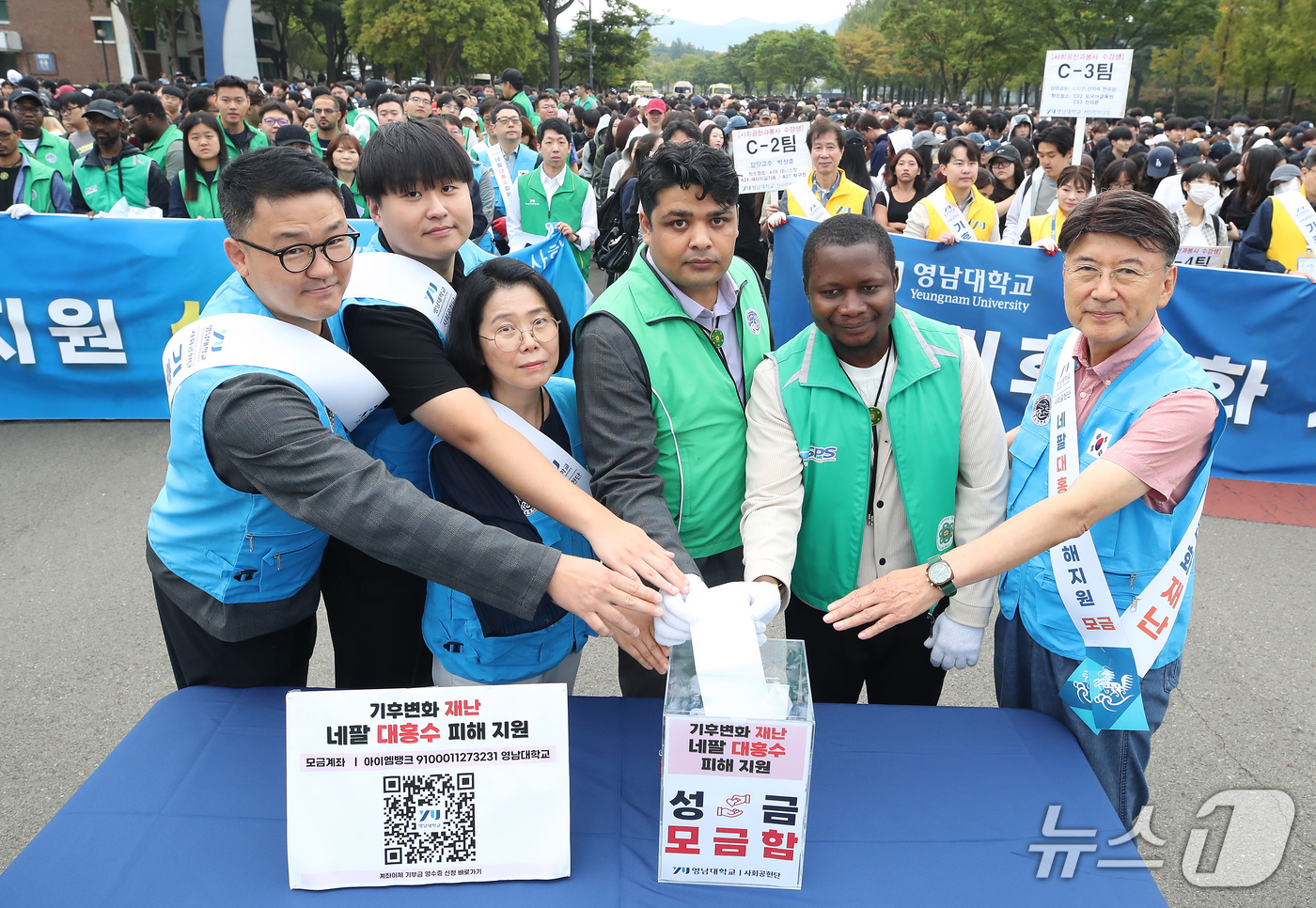 (경산=뉴스1) 공정식 기자 = 28일 최외출 영남대 총장(오른쪽)을 비롯해 학생, 유학생, 교수, 직원 등 대학 구성원들이 '네팔 대홍수 피해 지원 성금 모금'에 동참하고 있다. …
