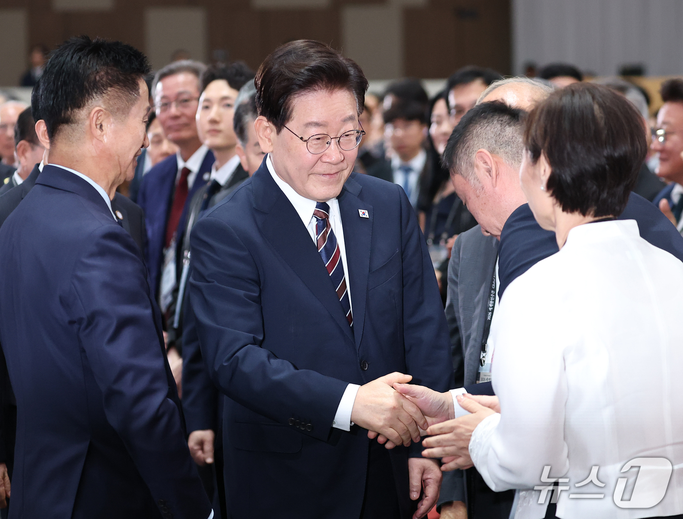 (인천=뉴스1) 이재명 기자 = 이재명 대통령이 28일 인천 송도에서 열린 제20회 세계한인의 날 기념식에 입장하며 참석자들과 인사를 나누고 있다. (청와대통신사진기자단) 2026 …