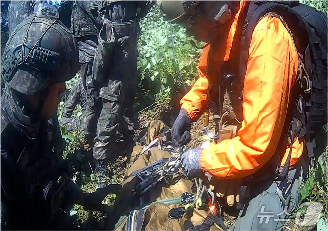 (서울=뉴스1) = 28일 서울 용산구 국방부에서 열린 DMZ 지뢰 추정 폭발 사고 브리핑에서 공개된 폭발 사고 이후 응급구조사의 부상자 이송 당시 사진. (합동참모본부 제공. 재 …