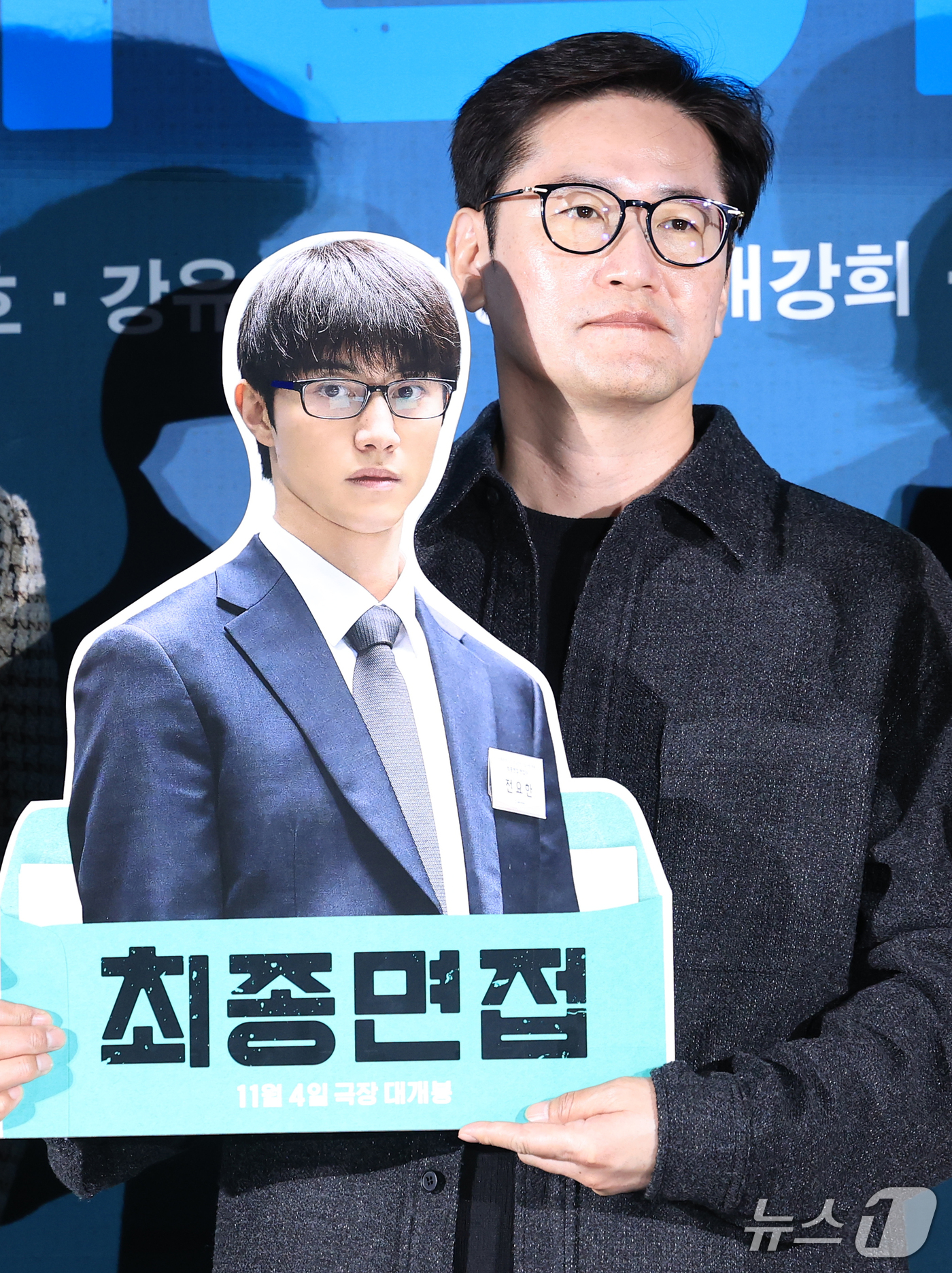 (서울=뉴스1) 권현진 기자 = 김정훈 감독이 29일 서울 광진구 롯데시네마 건대입구점에서 열린 영화 '최종면접' 제작보고회에서 군 복무중인 곽동연의 사진 보드를 들고 포즈를 취하 …