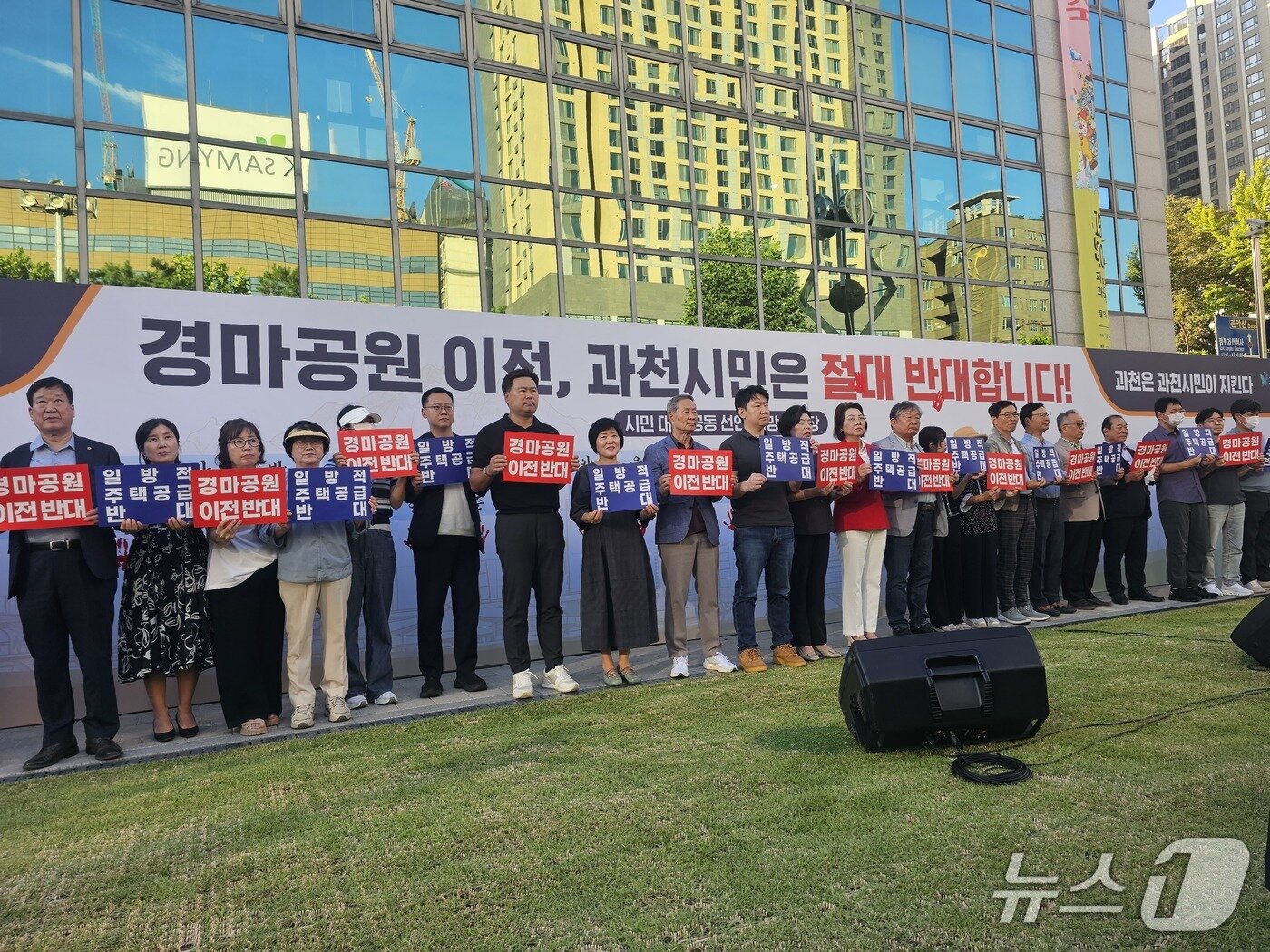 본문 이미지 - 시민대표33이 경마공원 부지 내 9800세대 주택공급 계획 관련 반대 문구가 적힌 팻말을 들고 퍼포먼스 하는 모습.2026.9.3 ⓒ 뉴스1 유재규 기자
