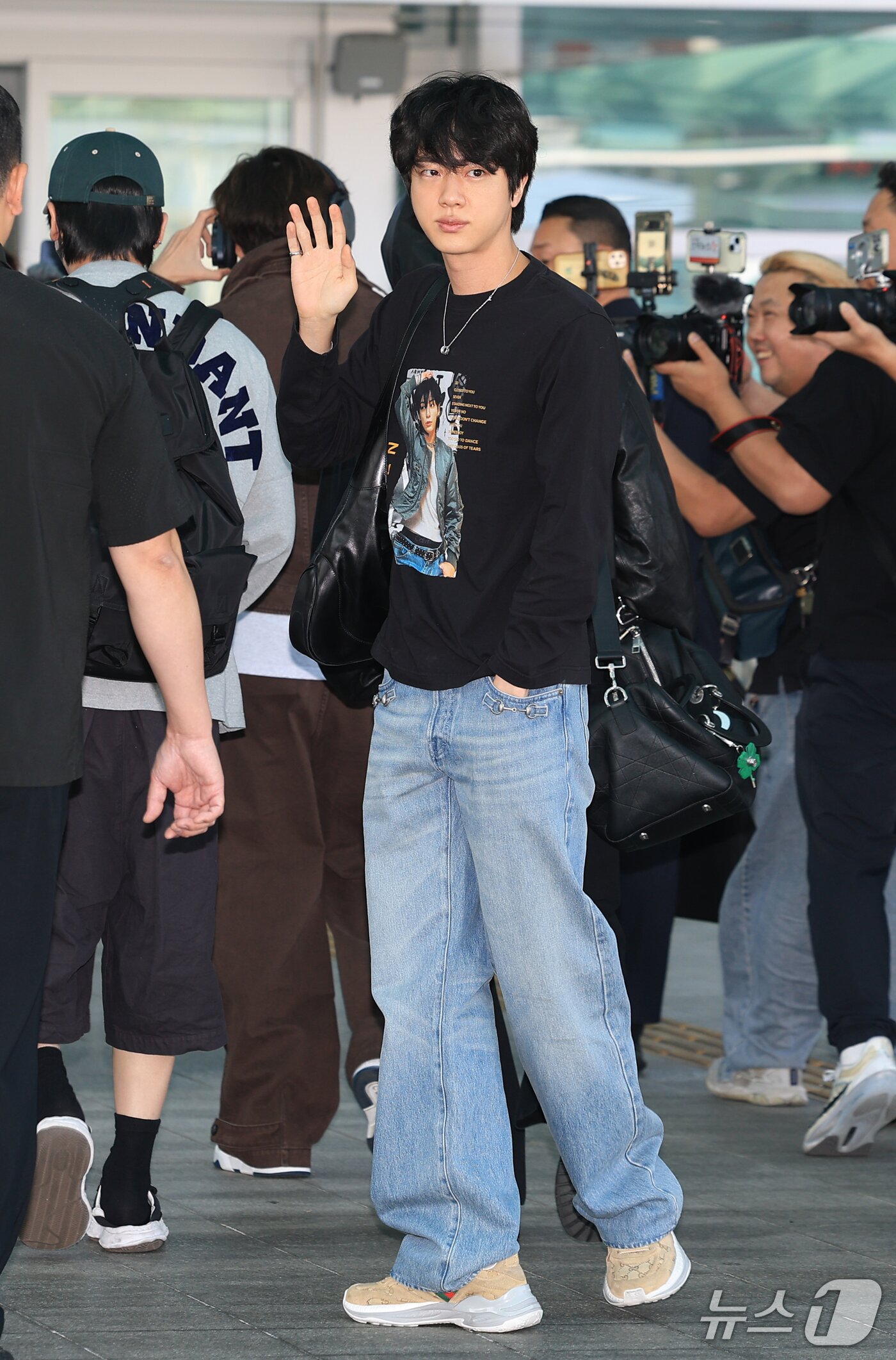 본문 이미지 - 방탄소년단(BTS) 진이 해외일정을 위해 30일 인천국제공항을 통해 미국 애틀란타로 출국하며 인사를 하고 있다. 이날 진은 멤버이자 아끼는 막내 정국의 사진이 프린팅 된 티셔츠를 입고 나와 눈길을 끌었다. ⓒ 뉴스1 권현진 기자