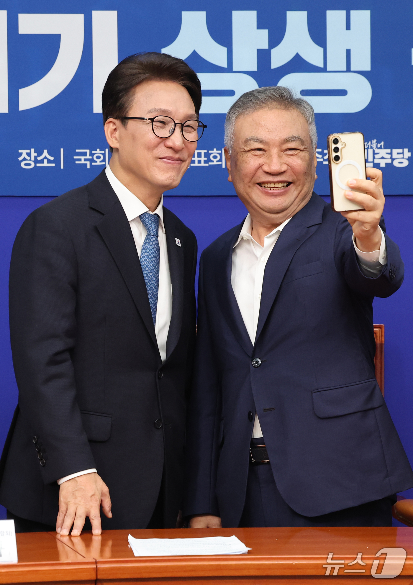(서울=뉴스1) 황기선 기자 = 김민석 더불어민주당 대표가 30일 오전 서울 여의도 국회에서 열린 을지로위원회 '乙' 살리기 상생 꽃 달기에서 김강삼 세븐브로이 대표이사와 셀카를 …