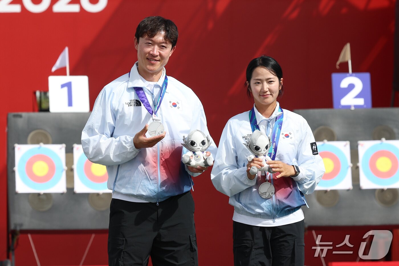 본문 이미지 - 대한민국 최용희, 박정윤이 30일 일본 오카자키 중앙종합공원 다목적광장에서 열린 2026 아이치·나고야 아시안게임 양궁 컴파운드 혼성 단체전 시상식에서 은메달을 목에 걸고 있다. 2026.9.30 ⓒ 뉴스1 안은나 기자