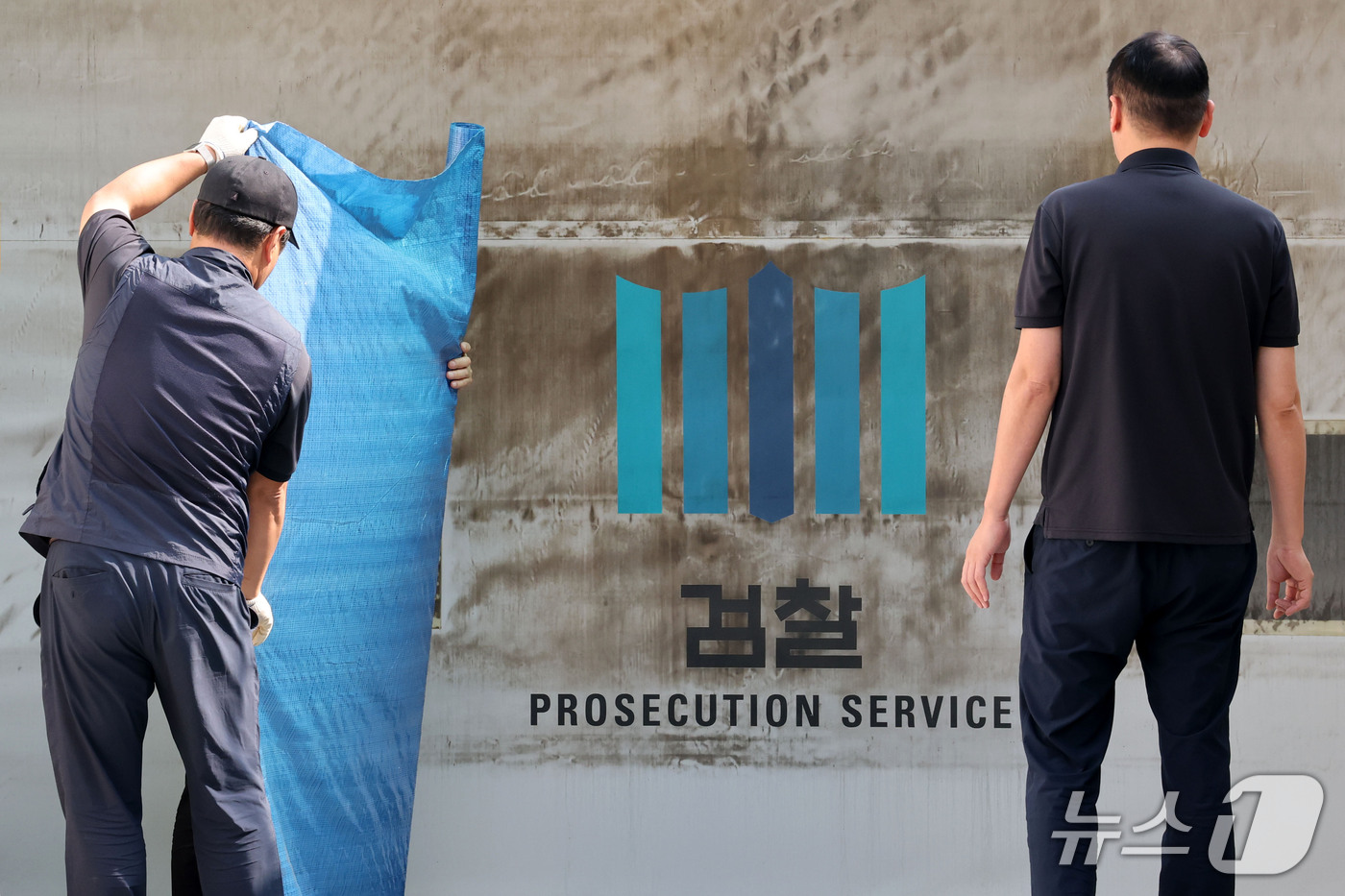 (서울=뉴스1) 이광호 기자 = 공소청·중대범죄수사청 출범을 이틀 앞둔 30일 서울 서초구 대검찰청에서 관계자들이 주차장 출입문에 새겨진 검찰 표식을 가리기 위한 준비작업을 하고 …