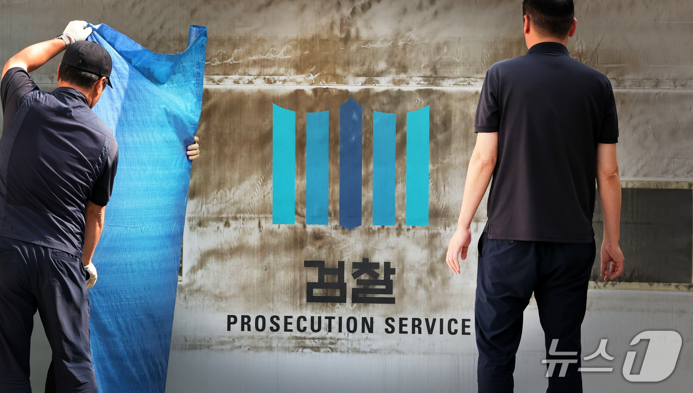 (서울=뉴스1) 이광호 기자 = 공소청·중대범죄수사청 출범을 이틀 앞둔 30일 서울 서초구 대검찰청에서 관계자들이 주차장 출입문에 새겨진 검찰 표식을 가리기 위한 준비작업을 하고 …