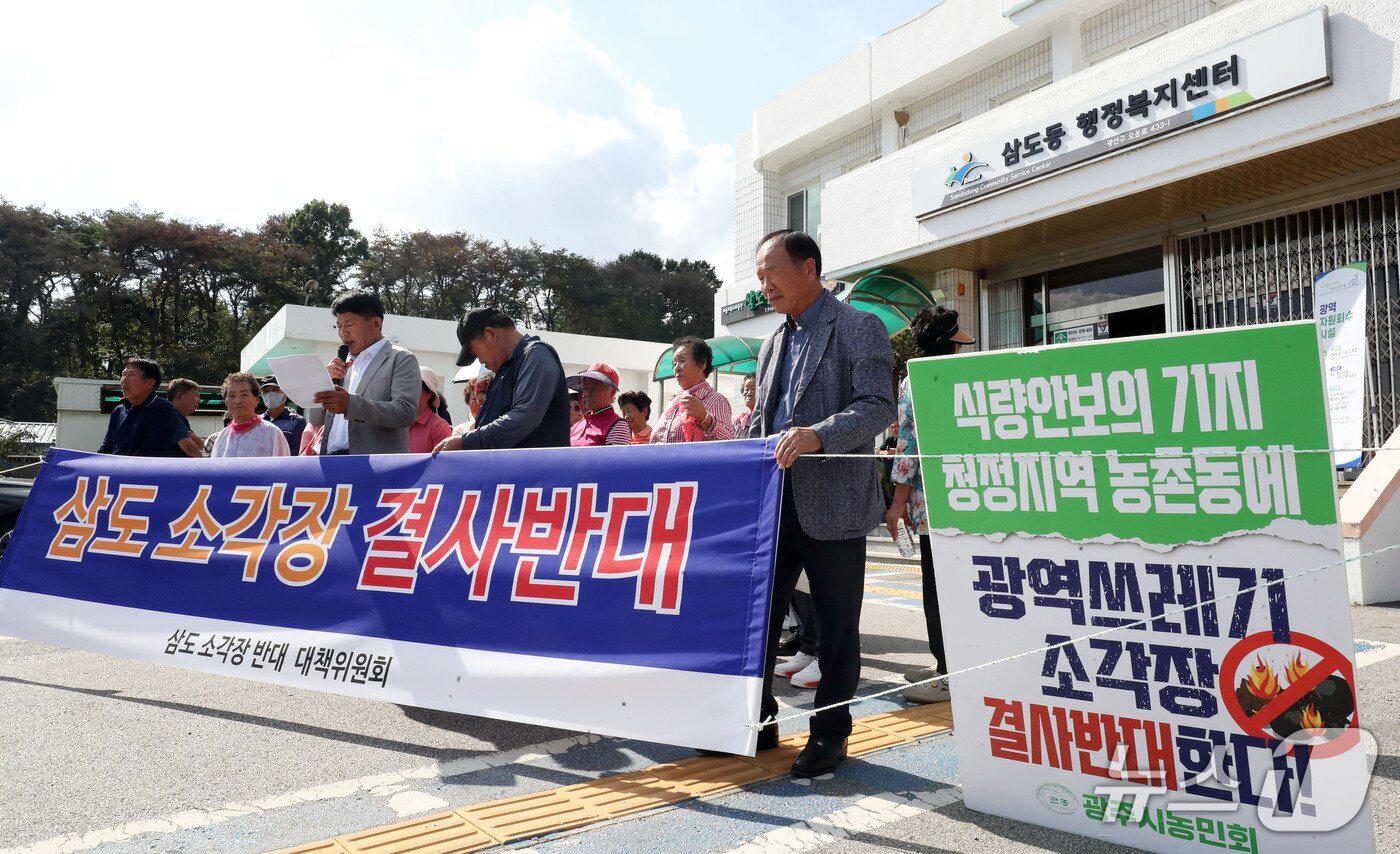 본문 이미지 - 삼도·함평 소각장반대대책위, 전국농민회총연맹 광주시농민회가 30일 오후 전남광주 광산구 삼도동 행정복지센터에서 예정된 자원회수시설 주민설명회를 앞두고 입구를 막은채 설명회 개최 반대를 촉구하고 있다. ⓒ 뉴스1 조수민 기자