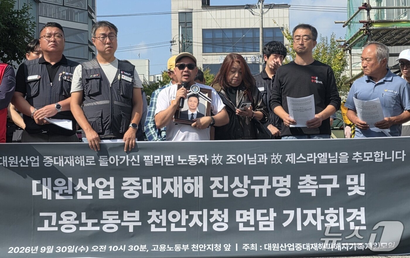 본문 이미지 - 30일 고용노동부 천안지청에서 열린 대원산업 중대재해 진상규명 촉구 기자회견에서 故 조이 칸토 씨의 유족이 영정 사진을 들고 있다./2026.9.30. ⓒ 뉴스1 이시우 기자