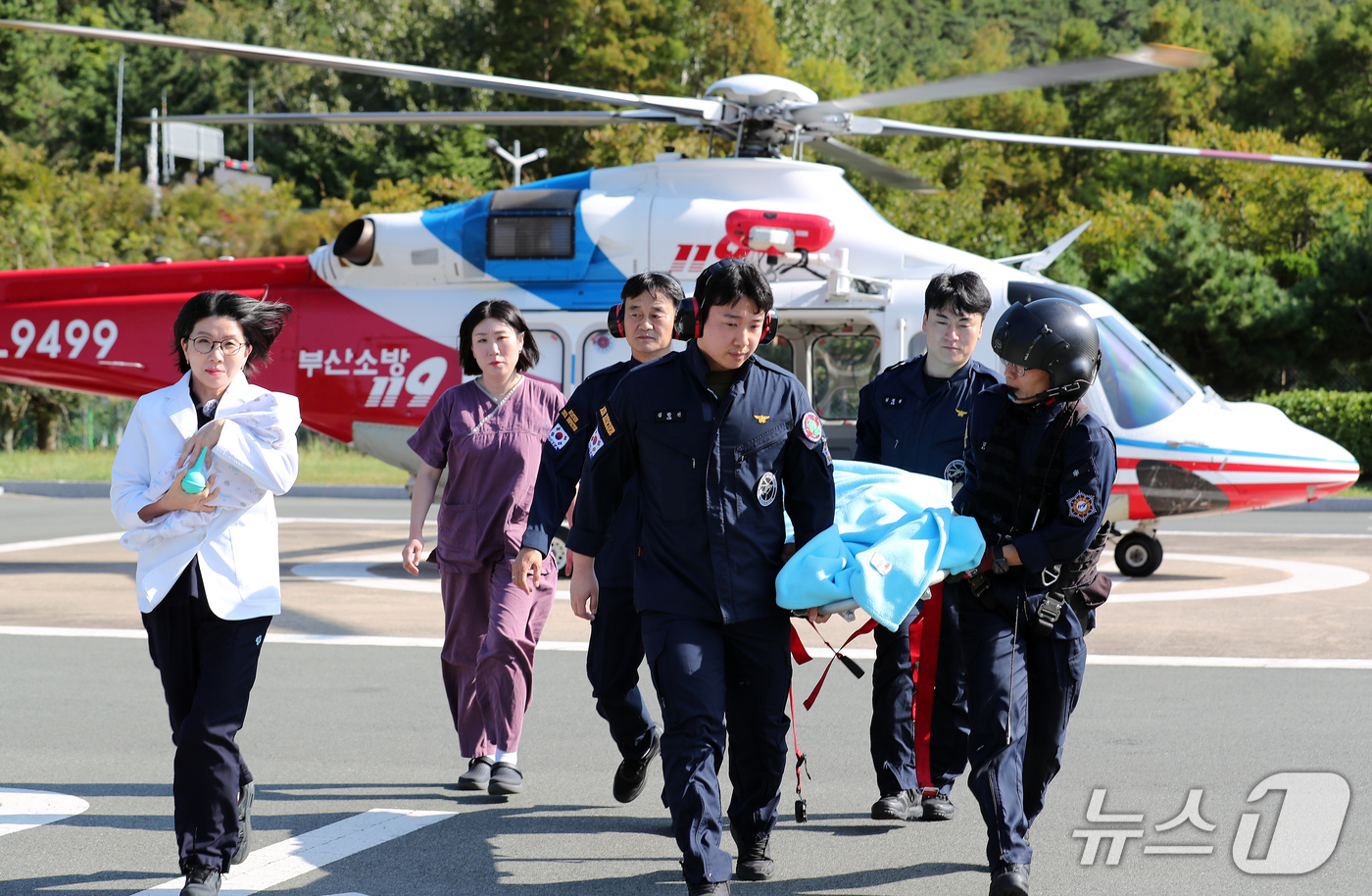 (부산=뉴스1) 윤일지 기자 = 30일 부산 해운대구 부산소방재난본부 119특수대응단 헬기장에서 119항공대원과 해운대백병원 권역모자의료센터 의료진이 '고위험 임산부·신생아 이송 …