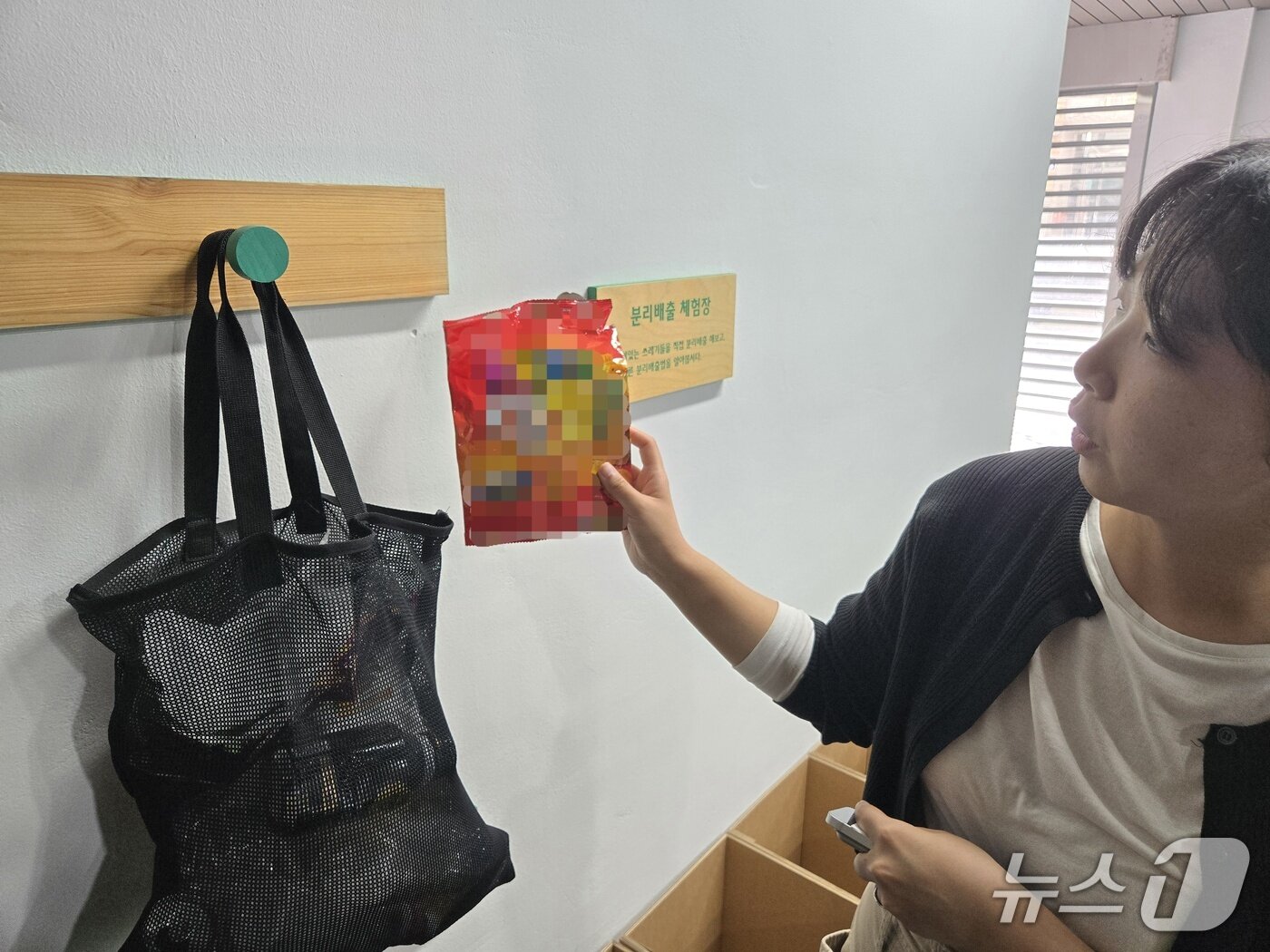 본문 이미지 - 3일 오전 서울 중구 '쓰레기연구소 새롬'에서 최연준 중구청 청소행정과 주무관이 과자봉지의 올바른 분리배출법을 소개하고 있다. 26.09.03 ⓒ 뉴스1 이상혁 기자