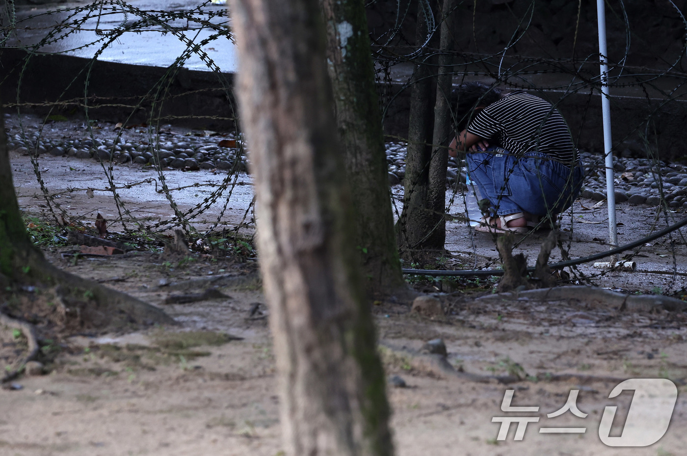 (바타르(네팔)=뉴스1) 구윤성 기자 = 4일(현지시간) 네팔 바그마티주 누와코트 지역 바타르의 군 기지 앞에서 한 어린이가 앉아 울고 있다. 이 기지에선 실종자 수색 구조 헬기가 …