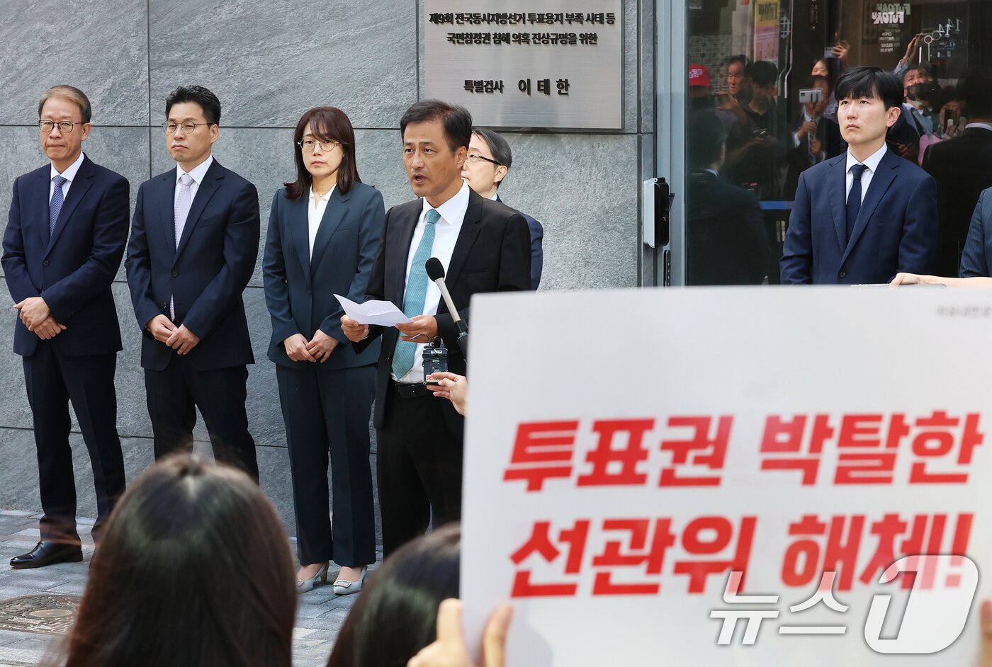 본문 이미지 - 6·3 지방선거 투표용지 부족 사태 등 중앙선거관리위원회를 둘러싼 의혹을 수사할 특별검사팀(선관위 특검) 이태한 특검이 7일 오전 서울 서초구 특검 사무실에서 열린 현판식에서 선관위 해체를 주장하는 피켓 시위대 앞에서 인사말을 하고 있다. 2026.9.7 ⓒ 뉴스1 오대일 기자