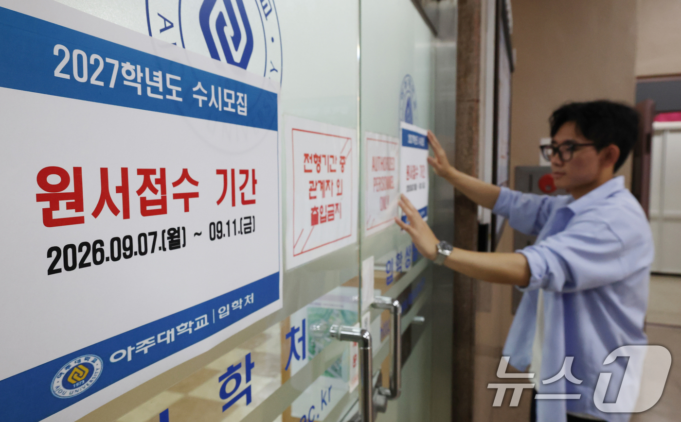(수원=뉴스1) 김영운 기자 = 2027학년도 수시모집 원서 접수가 시작된 7일 경기 수원시 영통구 아주대학교 입학처 앞에 관계자가 2027학년도 수시모집을 알리는 게시물을 부착하 …