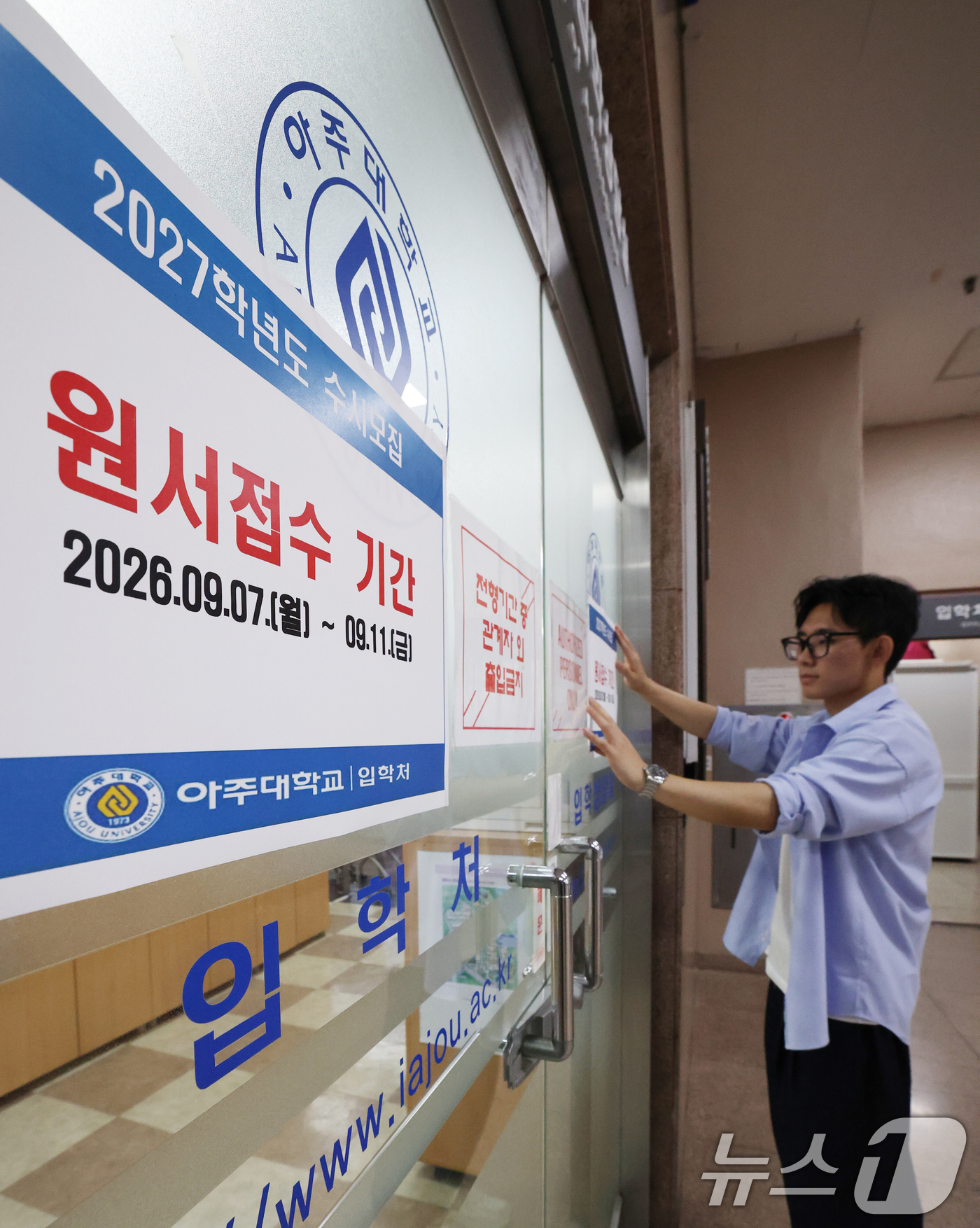 (수원=뉴스1) 김영운 기자 = 2027학년도 수시모집 원서 접수가 시작된 7일 경기 수원시 영통구 아주대학교 입학처 앞에 관계자가 2027학년도 수시모집을 알리는 게시물을 부착하 …