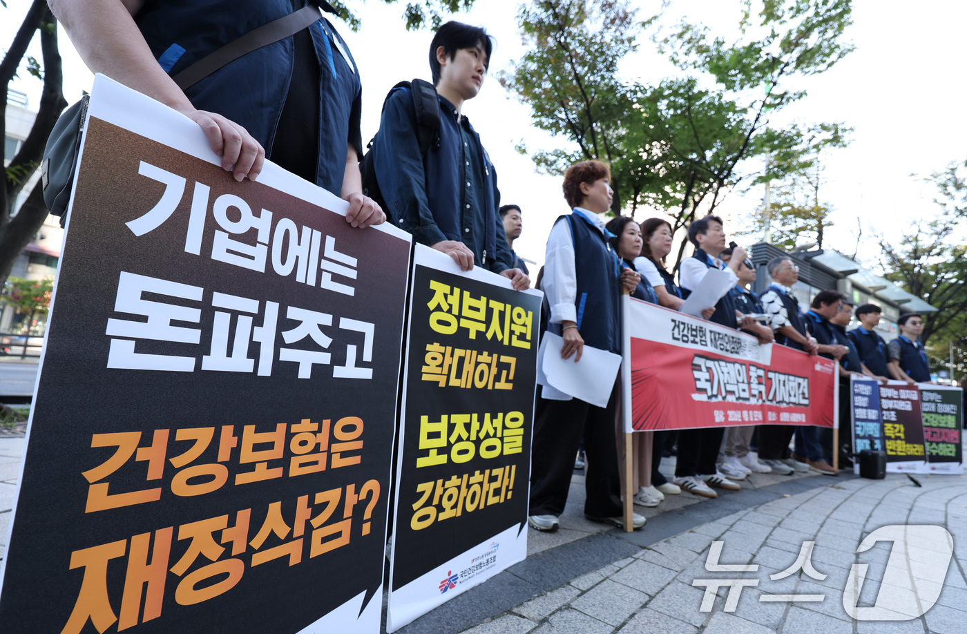 (서울=뉴스1) 박지혜 기자 = 민주노총 공공운수노조 국민건강보험노동조합 조합원들이 8일 서울 서초구 건강보험심사평가원 앞에서 열린 '건강보험 재정안정화를 위한 국가책임 촉구 기자 …