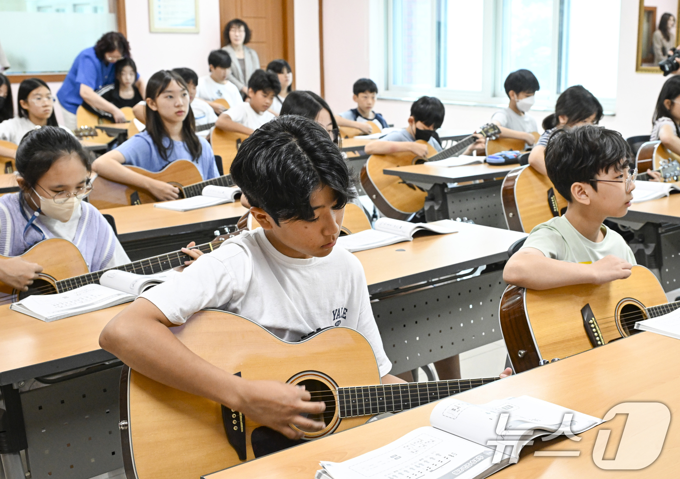 (오산=뉴스1) 김영운 기자 = 9일 경기 오산시 원동초등학교에서 학생들이 통기타를 배우고 있다. 고학년을 대상으로 정규 수업 시간에 진행되는 해당 수업은 전문 강사들이 참여해 학 …