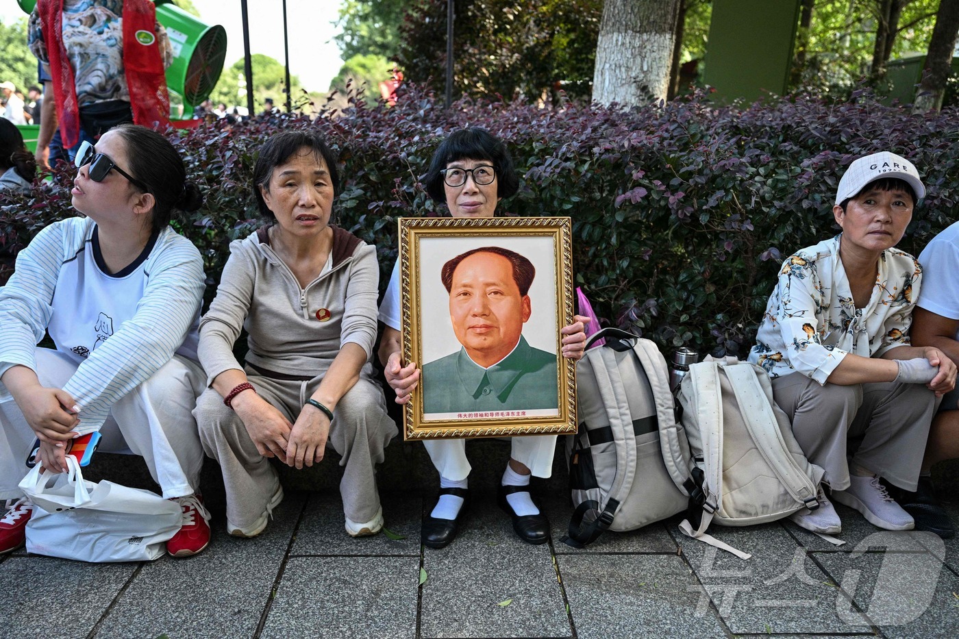 (샤오산 AFP=뉴스1) 김범수 수습기자 = 9일 중국 후난성 샤오산에 위치한 마오쩌둥 동상 광장에서 한 여성이 마오쩌둥 전 중국 국가주석의 초상화를 들고 있다. 이날은 마오쩌둥 …