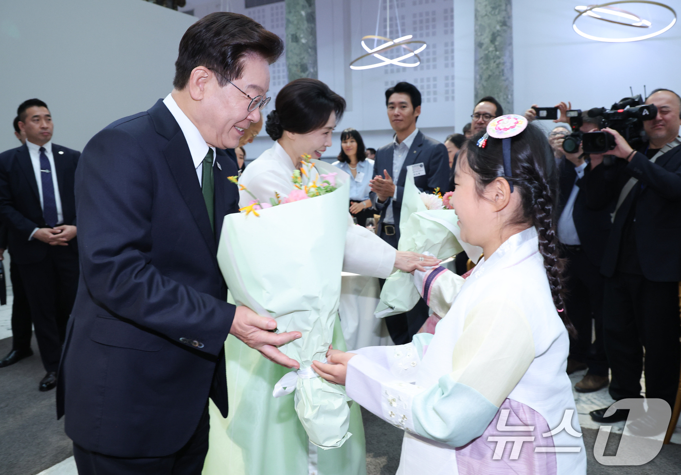 (파리(프랑스)=뉴스1) 이재명 기자 = 프랑스를 국빈 방문 중인 이재명 대통령과 김혜경 여사가 9일(현지시간) 파리 한 호텔에서 열린 동포 오찬간담회에서 화동에게 꽃다발을 받고 …